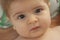 Nice closeup portrait of cute blond baby with brown eyes looking direct into the camera