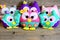 Nice colorful owls toys. Stuffed kids toys on vintage wooden background. Easy crafts made from felt