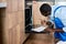 Nice Contractor Handyman In Overalls Looking inside of electric oven examining before repair