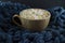 Nice Cup of coffee with marshmallow. Blue knitted background