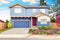 Nice curb appeal of blue house with front garden and garage