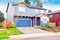 Nice curb appeal of blue house with front garden and garage with driveway