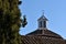 Nice dome with stained glass view behind a roof with a large cypress