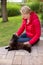 A nice elderly woman strokes her cat passionately