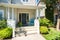 A Nice Entrance of the house with door steps and two chairs under the porch.