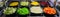 Nice fragment of view of beautiful appetizing fresh vegetable salads in dark ceramic plates