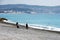 Nice, France, March 2019. Two fishermen fishing with fishing rods on the pebble beach of Nice. Cote d`Azur. Light fog hangs over