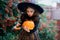 Nice girl of 8-9 years in suit for Halloween with a pumpkin into hands.