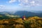 Among the nice green hummocks there is a red hair girl sitting at halt and watching the horizon with the beatufil mountains.