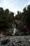 Nice image of the Dorothy Falls near the Kaniere Lake surrounded by trees taken on a cloudy day, New Zealand