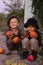 Nice kids sitting with Halloween pumpkins