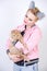 Nice kind woman with a short haircut and fur ears in sports clothes and jeans is holding her beloved pet on a white background in