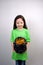 Nice littel girl in green dress looking at leprechaun\\\'s gold treasure in cast iron pot  decorated by clover leaf