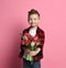 Nice little boy kid in blue jeans and red shirt gives a big bouquet of spring flowers for a Mothers day or other holiday
