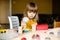 Nice little girl in the yellow dress playing with colorful bricks