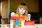 Nice little girl in the yellow dress playing with colorful bricks