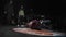 Nice long-haired guy in dark red sporty outfit performs breakdancing on stage