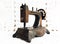 Nice miniature model of a vintage sewing machine on lacy background closeup