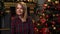 Nice new year portrait of young girl in red shirt sit near christmas tree.