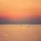 Nice pastel sunrise; fishing boat going to the sea early morning