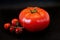 Nice picture for desktops - a big and some small red tomatoes against a black background