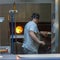 A nice pizza maker while working with the oven inserting one of his excellent pizzas