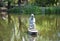 A nice place to visit. Statue of human in middle of lake. Pond sculpture in stone outdoor. Stone statue. Carved stone male figure