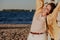 Nice plus size girl leans on wooden structure on beach