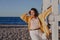 Nice plus size girl leans on wooden structure on beach