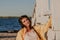 Nice plus size girl leans on wooden structure on beach