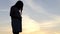 Nice pregnant woman stands on a lake bank at sunset in slo-mo