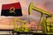 Nice pumpjack oil extraction and cloudy sky in sunset with the Angola flag