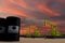 Nice pumpjack oil extraction and cloudy sky in sunset with the KUWAIT PETROLEUM CORPORATION flag on oil barrels 3D rendering