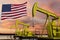 Nice pumpjack oil extraction and cloudy sky in sunset with the United States of America flag