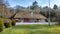 A nice restaurant made of wood with thatched roof. trees and forest in the background and lawn in the foreground