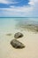 Nice rocks in the clear sea with blue sky and white clouds in the background