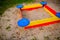 A nice sandbox playground filled . Surrounded by green grass,