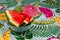 Nice shot of watermelon wedges in a bowl on a colorful tablecloth, decorated with a tiny umbrella