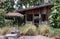 Nice small wooden hut. Green garden joy in summer with Stone benchs and perennial ryegrass plant