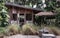 Nice small wooden hut. Green garden joy in summer with Stone benchs and perennial ryegrass plant