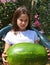 Nice smiling little girl with an enormous WATERMELON