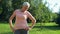 Nice sporty elderly woman doing stretching exercise outdoors