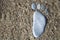 Nice stone made footprint on the sand shore, background