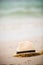 Nice straw hat laying on the sand. Beautiful ocean beach background. Outdoors. Vacation time. End of summer vacations