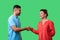 Nice to meet you! Portrait of happy young couple in casual wear shaking hands. isolated on green background