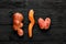 Nice vegetables. Two potatoes of a strange ugly shape and twisted carrots on a black wooden background