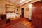 Nice warm interior of bedroom in a rustic style in country house or hotel. Wooden beams and walls made of natural stone.