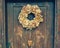 Nice wooden country front door in Europe alp village with vintage hipster wreath. Toned