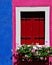 Nice wooden window with flowers and bright blue, red, pink and white colors, Burano, Venice, Italy