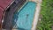 Nice young woman in blue bikini dives into pool and swims, enjoying her holidays